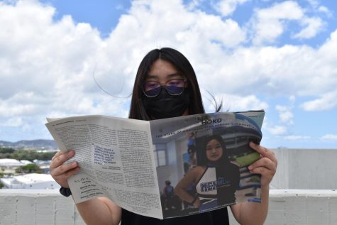 Moanalua student wearing a mask while reading a Na Hoku News magazine