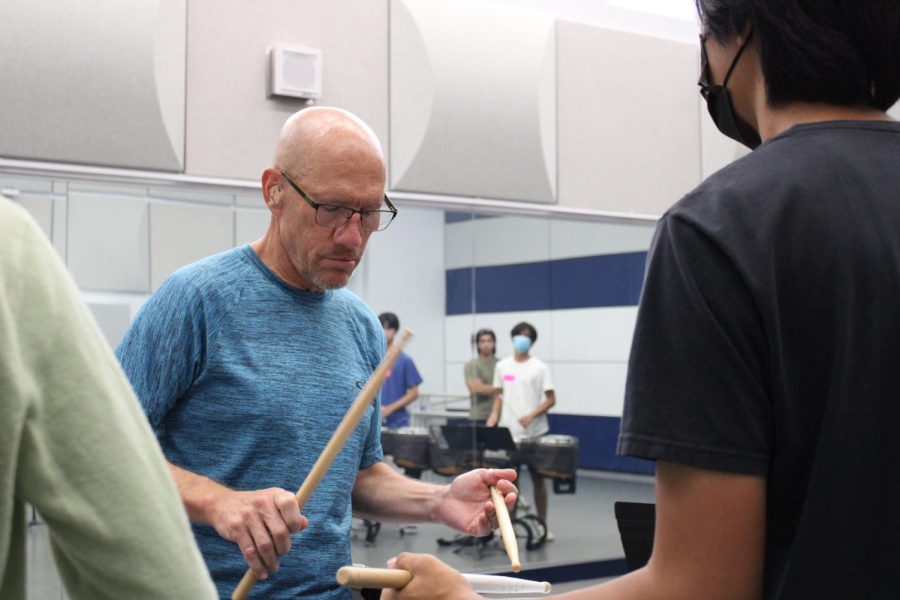 Bret+Kuhn+demonstrates+a+drum+roll+to+marching+band+students.