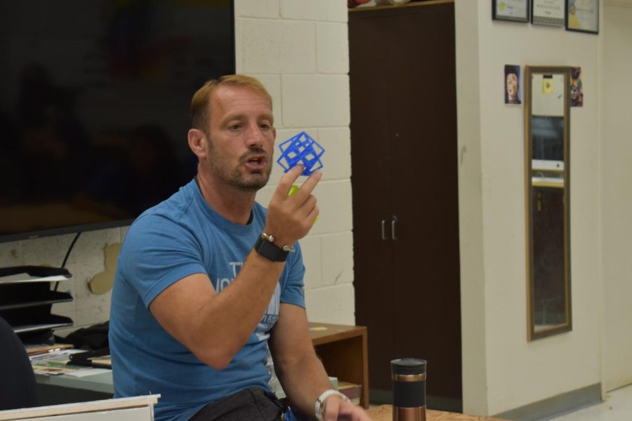 Engineering teacher Vince Komar holds up a project students can create using a 3-D printer.