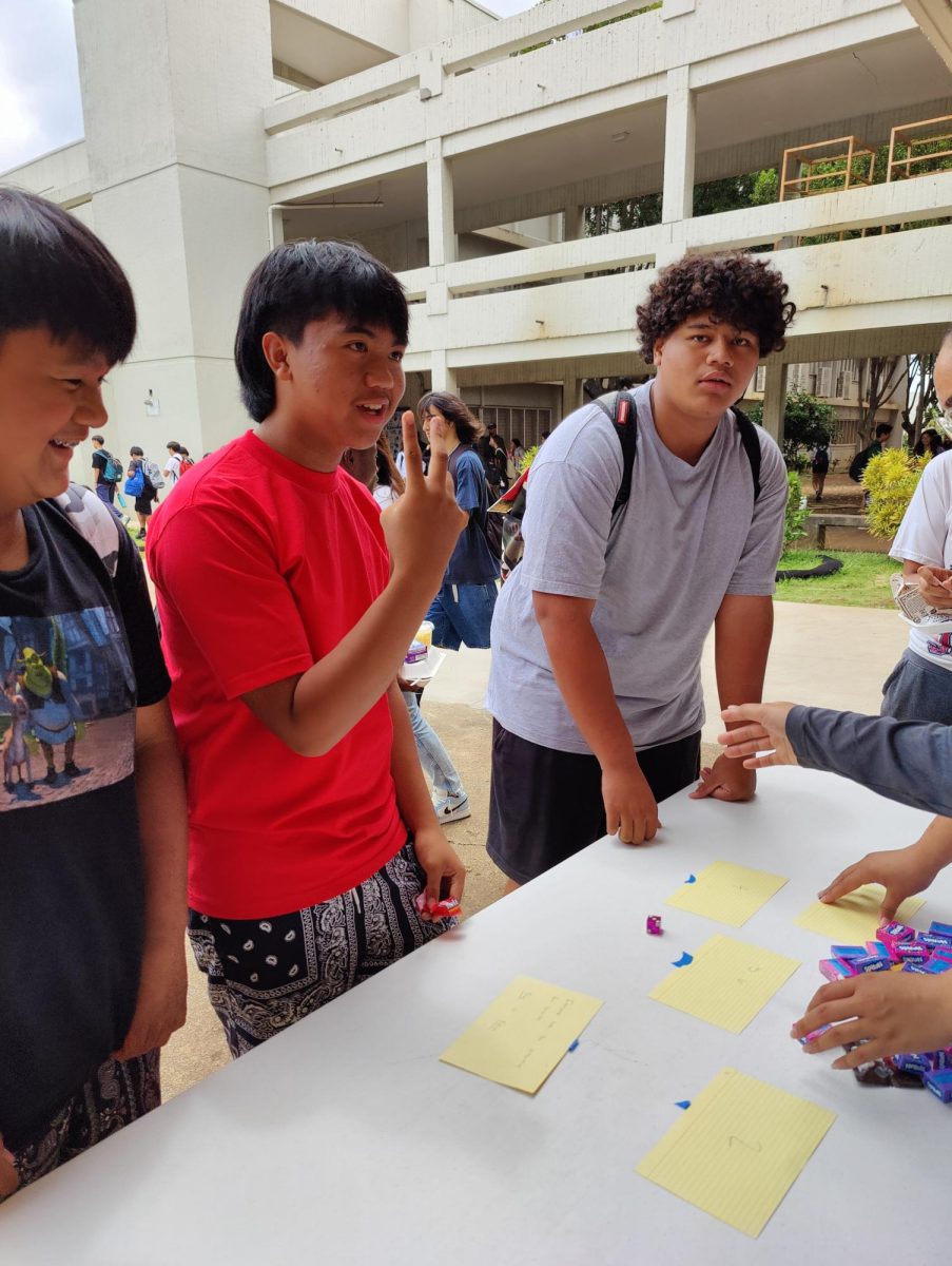Freshman Jancen Vinluan answers a question about suicide facts Wednesday and wins a prize.  Hawaii Cares is a local, 24/7 crisis hotline. People can call (808) 832-3100 for immediate assistance.