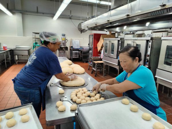 Addie LeeHong (left) and Joyce Faris prepare hundreds of dough balls for rising before baking.