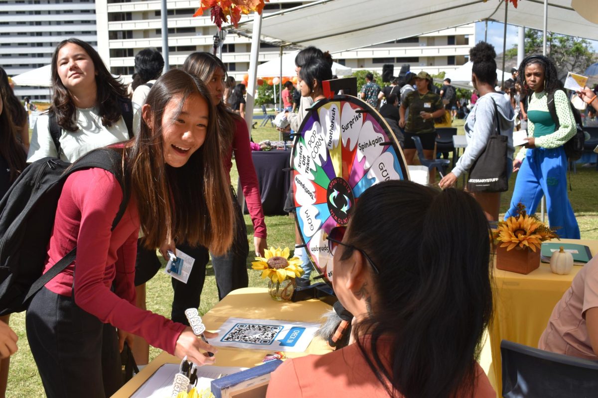 Freshman Cami Furutani answered a question and spun the wheel for prizes at the Dung Mililani Orthodontics booth.