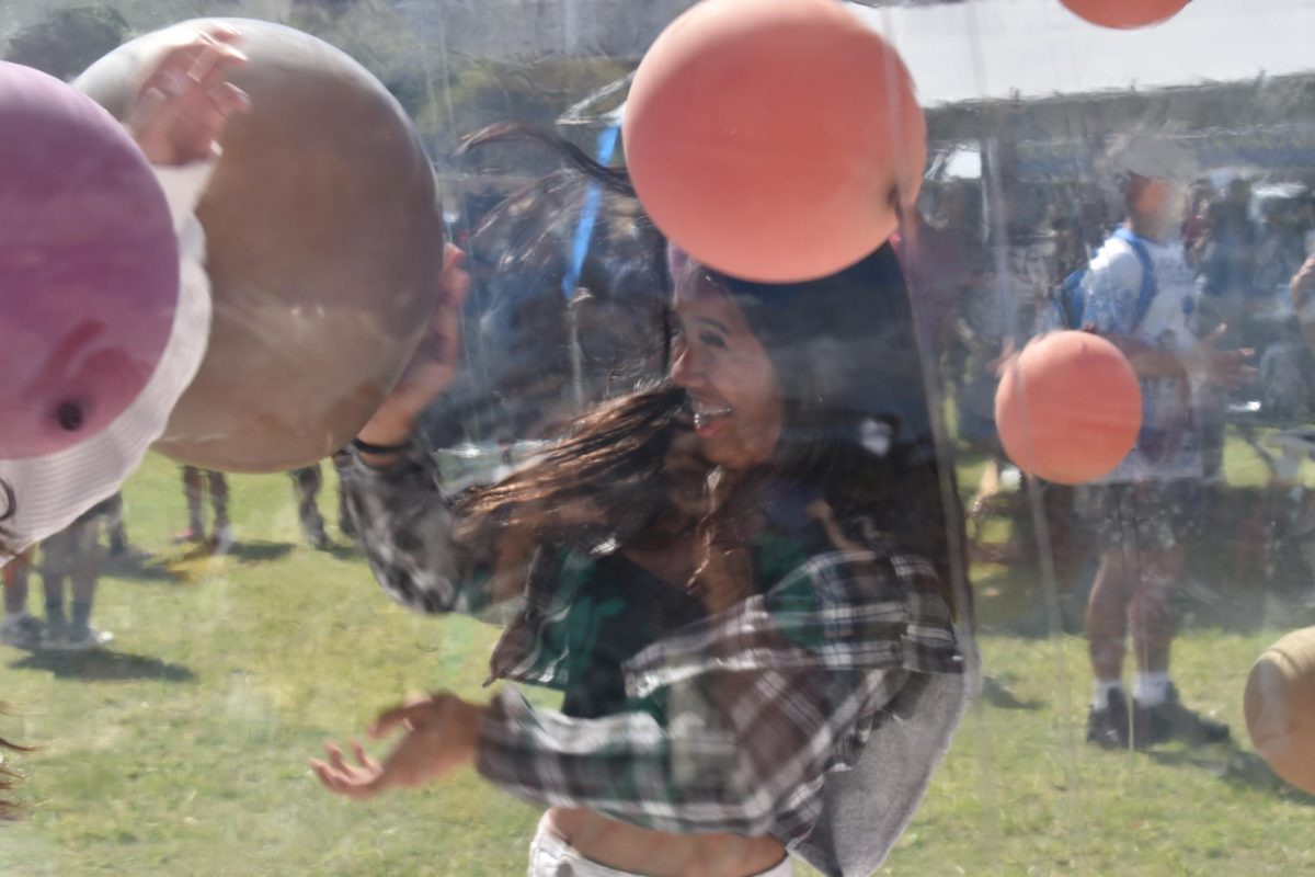 Junior Jewlia Madriaga tries to catch and toss the balloons in the plastic balloon globe  bouncy house.