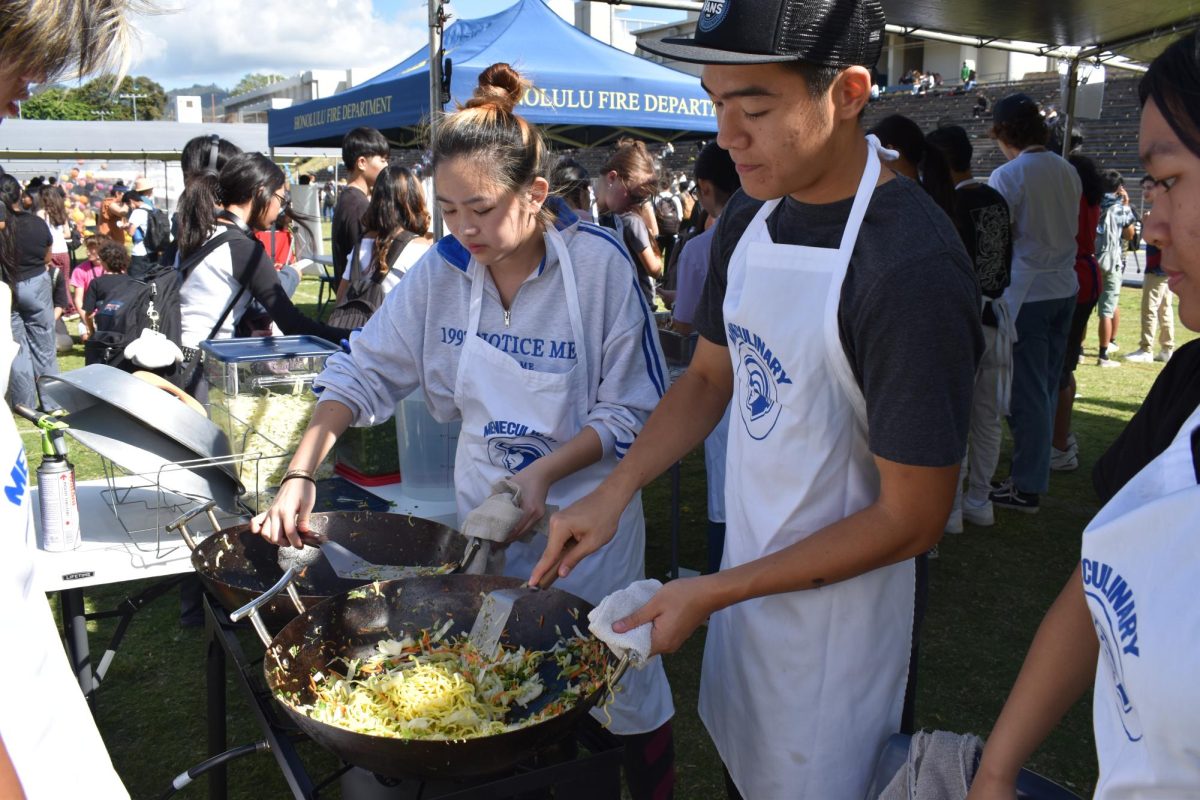 Seniors Lei Shinshiro and James Huang fried noodles with vegan teriyaki spam in the booth run by  the culinary classes. The students sold more than 1,000 bowls of noodles.
