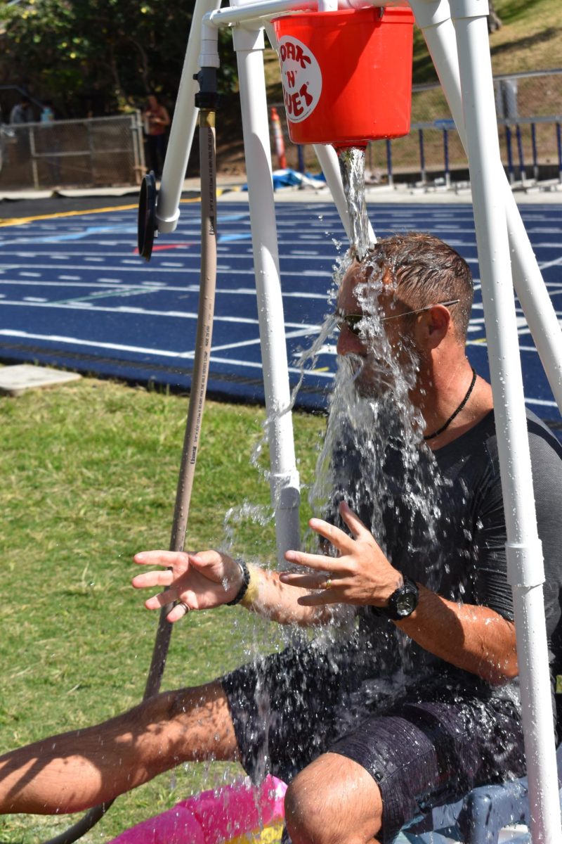Engineering teacher Vince Komar got drenched in the Soak N Wet booth after daring one of his students to hit the target with the bean bag. He got his wish.  Students could earn a free chance to play by obtaining 15 stamps from the various booths at the health fair.