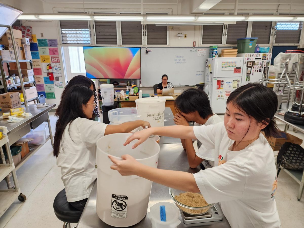 Left: Senior Miley Chun and (behind) senior Cristanie Rodriguez work with senior Isaac Dacanay and junior Kiana Watanabe to measure the ingredients for the s’mores cookies. Because of the number of cookies the students had to make, they used five-gallon buckets rather than traditional mixing bowls.