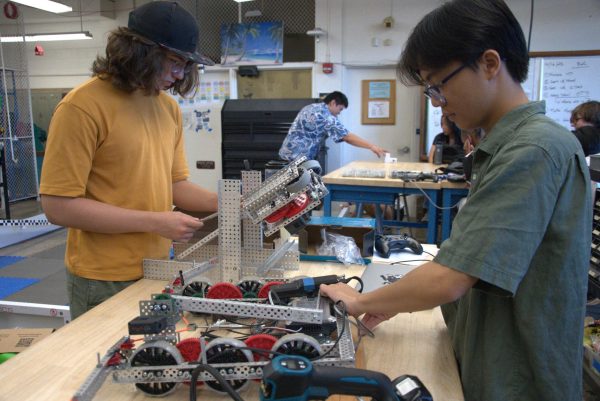 Robotics Club President Logan Downing (left) and Robotics Club Vice President Matthew Tran (right) work on the team robot. The team meets anywhere from two to four afternoons a week.