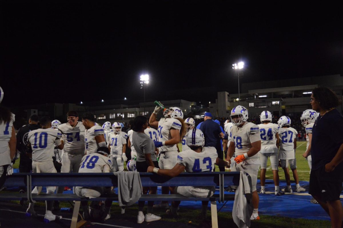 The Moanalua Na Menehune football team all gather around the bench during a timeout.