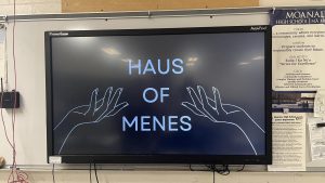 A stark "Haus of Menes" opening slide awaits club members as they walk in before their first club meeting begins.