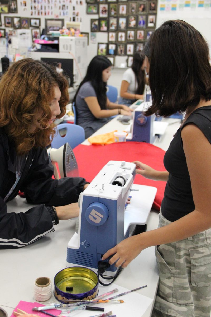 Club President Saige Chung (10) teaches Arleigh Ross (12) how to sew.
