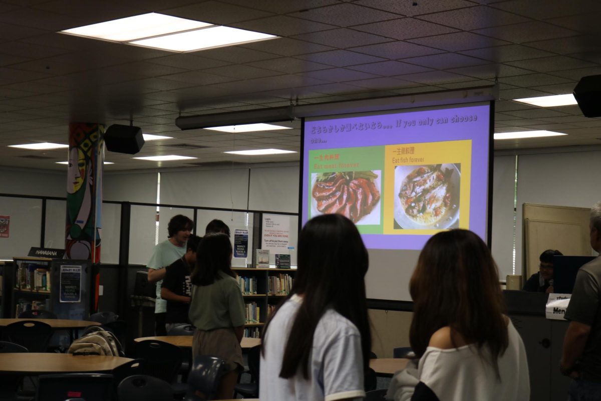 Japanese Club members playing “would you rather.” The question on the slide: Eat meat forever or eat fish forever?
